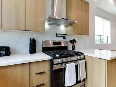 a kitchen with a stove and white counter tops at Modern Luxe Retreat Four-Bedroom in Los Angeles