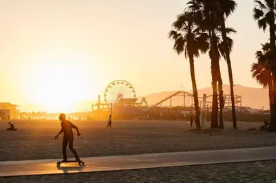 a person riding a skateboard on a beach with a ferris wheel at Beautiful 2bd 2bth apartment in Santa Monica in Los Angeles