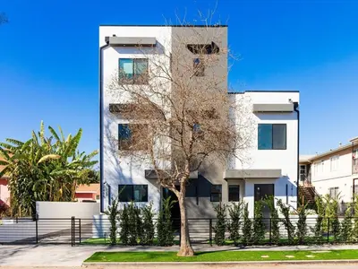 a tall white building with a tree in front of it at Modern Luxe Retreat Two-Bedroom in Los Angeles
