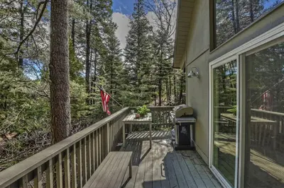 a porch of a house with a flag on it at Cozy Escape- Walking Distance to Village! in Lake Arrowhead