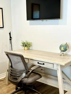 a desk with a chair and a television on a wall at Cactus Casino with game room next to Yaamava Casino in Highland