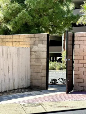 an open gate in a brick wall next to a fence at Cactus Casino with game room next to Yaamava Casino in Highland