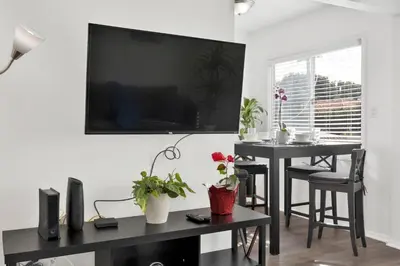 a living room with two tables and a television on a wall at Cozy, Luxurious, Oasis, With Free parking in Los Angeles