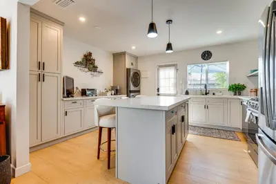 a large kitchen with white cabinets and a white island at 1 Mi to Rose Bowl! Updated Home with Furnished Deck in Pasadena