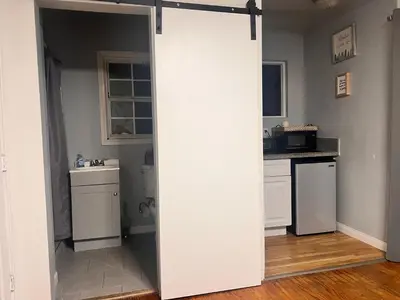 a white sliding door in a kitchen with a counter at Beautiful private upstairs studio - USC, LAX, SOFI in Los Angeles