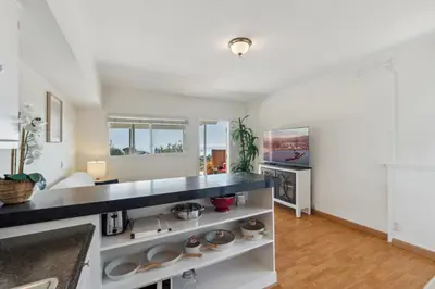 a kitchen with white walls and a black counter top at Whitney Oceanview Studio in Summerland