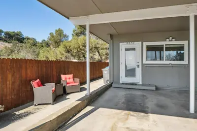 a patio with two chairs and a fence at Whitney Oceanview Studio in Summerland