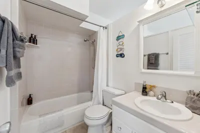 a white bathroom with a sink and a toilet at Whitney Oceanview Studio in Summerland