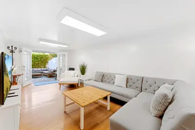a white living room with a couch and a table at The Hidden Hideaway in Summerland