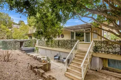 a house with stairs and a tree in the yard at Summerland Beach Oasis- Pet Friendly in Summerland