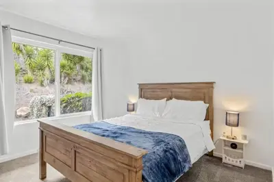 a bedroom with a bed and a large window at Summerland Beach Oasis- Pet Friendly in Summerland
