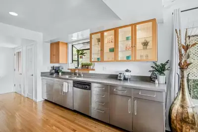 a kitchen with stainless steel appliances and wooden cabinets at Summerland Beach Oasis- Pet Friendly in Summerland
