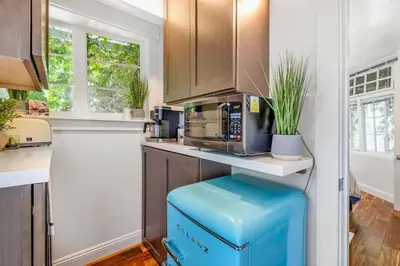 a kitchen with a counter with a blue ottoman at Gillians Room- Pet Friendly in Summerland
