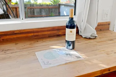 a bottle of wine sitting on top of a wooden floor at The Grand Escape - Casita Sonrisa in Summerland