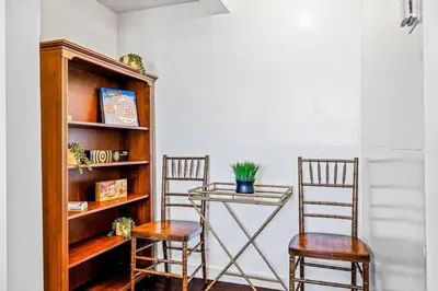 two chairs and a glass table next to a book shelf at The Grand Escape - Casita Sonrisa in Summerland