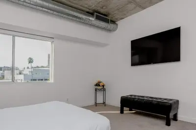a white bedroom with a bed and a large window at On Sunset Blvd - 5 star retreat in Los Angeles