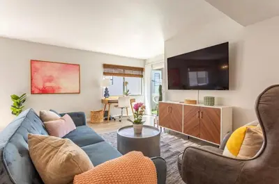 a living room with a blue couch and a tv at 3BR Townhouse in Prime Manhattan Beach Location in Manhattan Beach