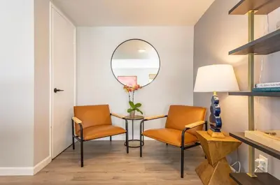 a room with two chairs and a table and a mirror at 3BR Townhouse in Prime Manhattan Beach Location in Manhattan Beach