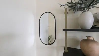 a mirror on a wall with a vase and a table at Seaside Sanctuary - Rooftop Deck & Hot Tub in Hermosa Beach