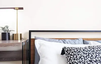 a bed with white pillows and a table with a lamp at Seaside Sanctuary - Rooftop Deck & Hot Tub in Hermosa Beach