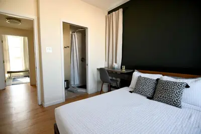 a bedroom with a bed and a desk and a room at Seaside Sanctuary - Rooftop Deck & Hot Tub in Hermosa Beach