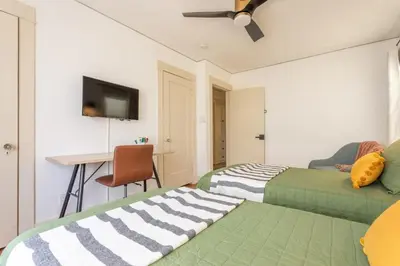 two beds in a room with a table and a desk at Charming 1920s Hermosa Bungalow Steps from The Strand in Hermosa Beach