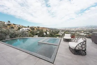 a swimming pool on a patio with two chairs at Hollywood hill stunning view cozy private room in Los Angeles