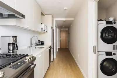 a kitchen with white cabinets and a stove at Blueground Downtown elevator nr parks LAX-1245 in Los Angeles