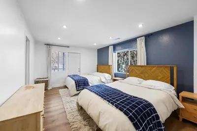 two beds in a bedroom with blue walls at THE Cabin in Running Springs