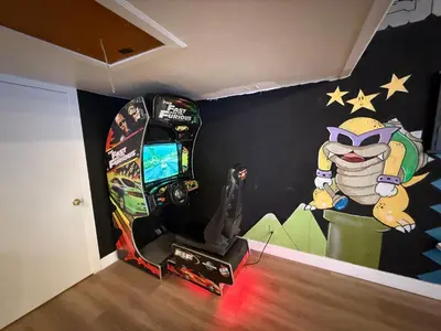 a room with a video game arcade and a mural at THE Cabin in Running Springs