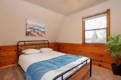 a bedroom with a bed and a window at Kelley's Kabin #290 in Big Bear Lake