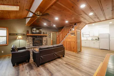 a living room with a ceiling fan and a fireplace at Kelley's Kabin #290 in Big Bear Lake