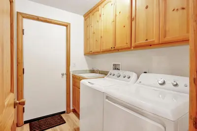 a white washer and dryer in a kitchen with wooden cabinets at Oriole House #2518 in Big Bear Lake