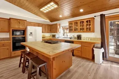a large kitchen with wooden cabinets and a large island at Oriole House #2518 in Big Bear Lake