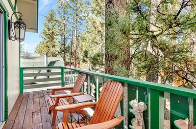 two chairs sitting on a deck with trees at Green Squirrel Chateau #2484 in Big Bear Lake