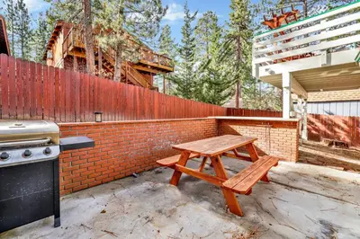 a wooden picnic table sitting next to a brick wall at Green Squirrel Chateau #2484 in Big Bear Lake