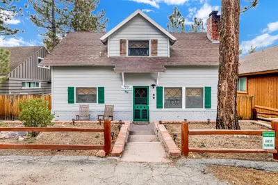 a white house with a green door and fence at Camp Conklin #2337 in Big Bear Lake