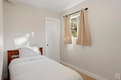 a white bedroom with a bed and a window at Temple Bear Chalet #2507 in Big Bear Lake