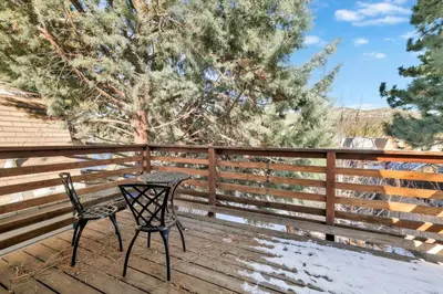 a table and chairs on a deck with a fence at Aeroplane Gambrel #2509 in Big Bear City