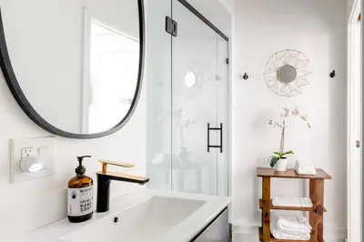 a bathroom with a white tub and a large mirror at Sleek Luxury Studio with Patio LAX & Beach Access in Los Angeles
