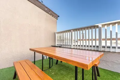 a wooden bench sitting on top of a balcony at Exclusive Ocean & Pier View Family Escape in Manhattan Beach