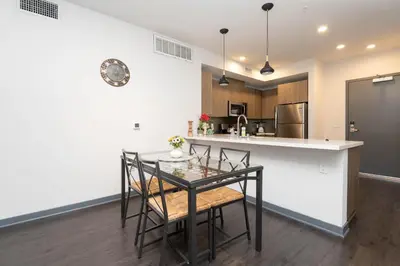 a kitchen with a table and chairs and a counter at Lovely 3BR Apt With Balcony And Rooftop Pool Plus Views in Los Angeles