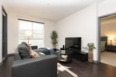 a living room with a couch and a television at Lovely 3BR Apt With Balcony And Rooftop Pool Plus Views in Los Angeles