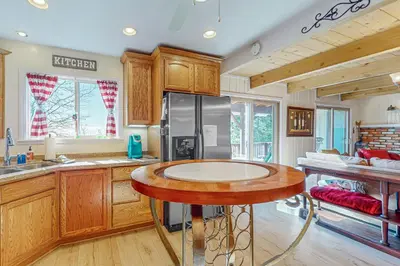 a kitchen with a table and a refrigerator at Tree-mendous Skypark-View Cabin in Skyforest