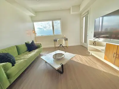 a living room with a green couch and a table at Top Floor Hollywood 1BR Condo with Views in Los Angeles