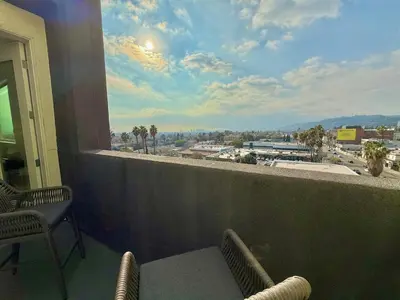 a balcony with chairs and a view of a city at Top Floor Hollywood 1BR Condo with Views in Los Angeles
