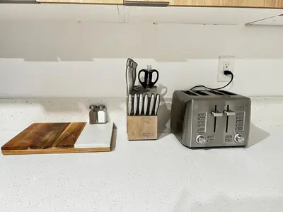a toaster on a counter with a cutting board and scissors at 6 miles from Disney, Book your dream vacations! in Fullerton