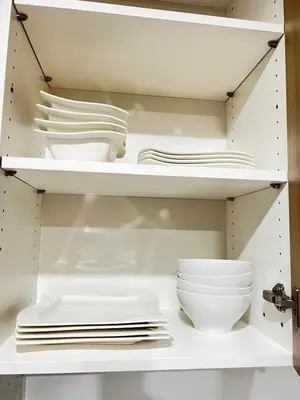 a closet with white plates and bowls on shelves at 6 miles from Disney, Book your dream vacations! in Fullerton
