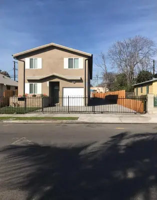 a house on a street with a fence at VWM Hostel in Los Angeles