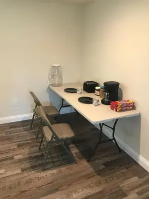 a white table with chairs and a coffee maker on it at VWM Hostel in Los Angeles